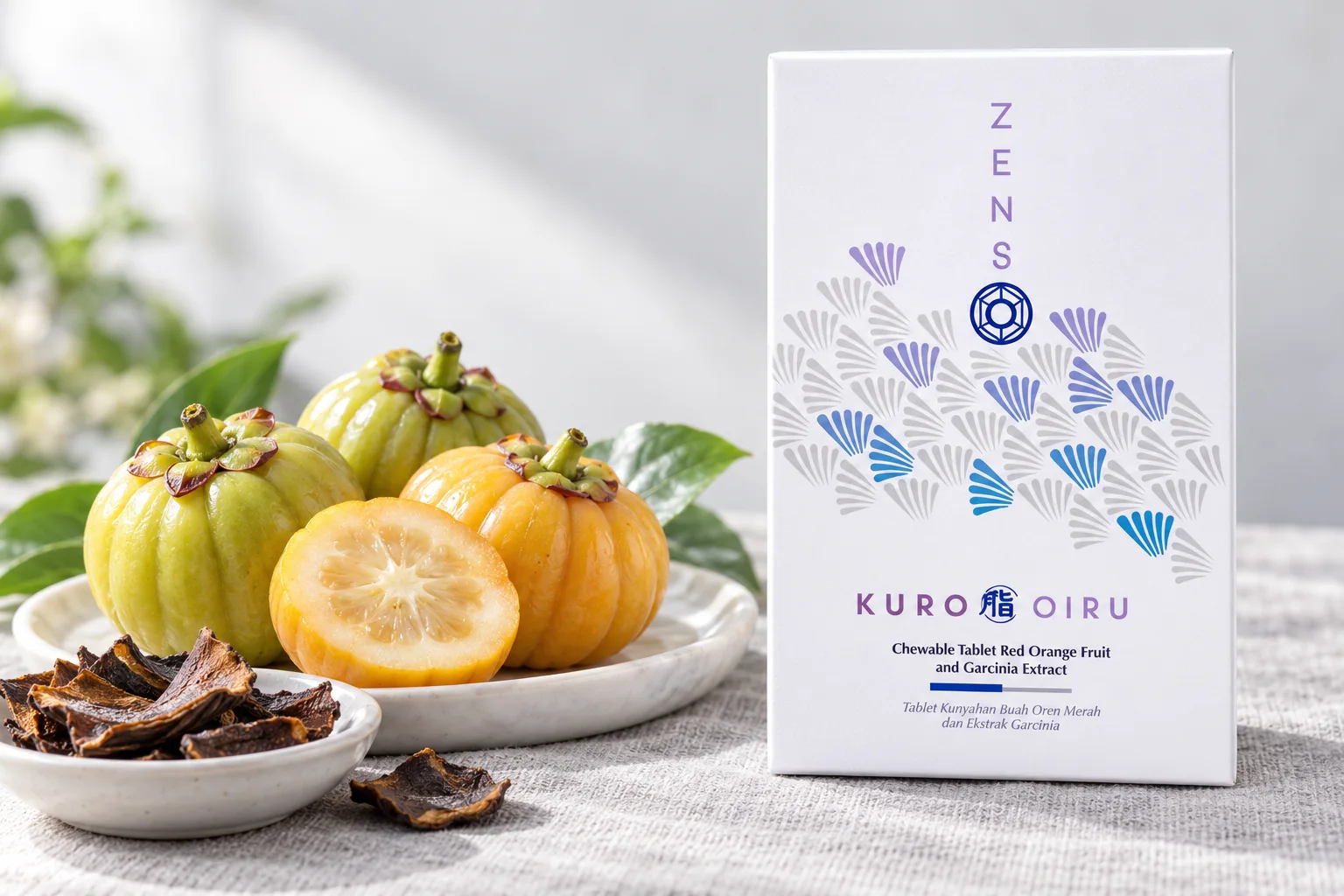 KURO OIRU 超燃紅橙錠盒裝，旁邊是新鮮藤黃果與曬乾的果皮